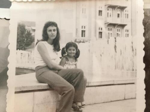 Emanuela with her mother in front of typically socialis-building